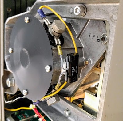 The head positioning motor moves the heads back and forth. Drive wires (yellow) are bolted to the motor. A bypass capacitor (black) is connected across the motor.