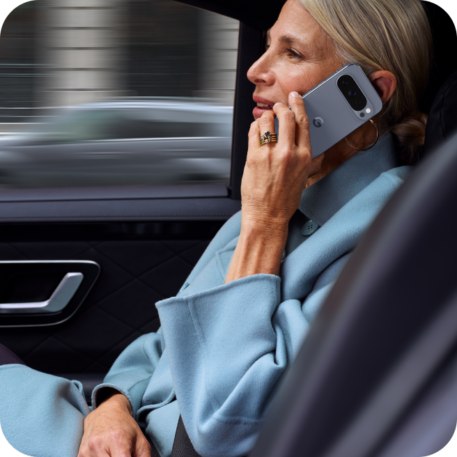 A woman working on her Google Pixel 10 Pro from her car.