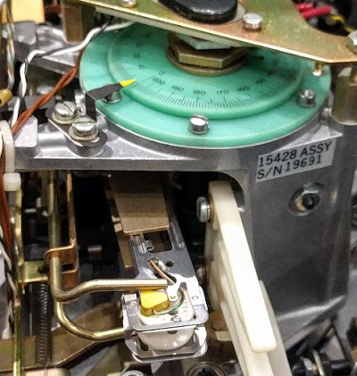 The green head positioner transducer provides feedback to the head servo mechanism. The pointer and dial indicate what track the heads are on.